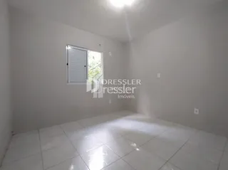 Interior de um cômodo com piso de cerâmica e paredes brancas.