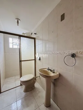 Foto de um banheiro com piso de cerâmica e louças brancas.