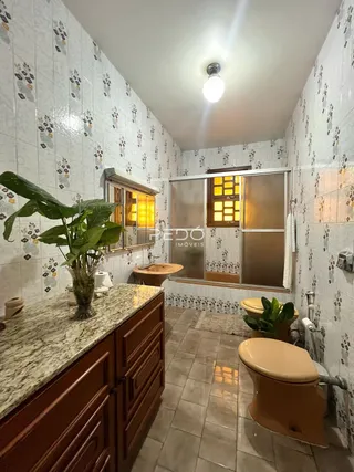 Foto de um banheiro com revestimento de azulejos brancos.