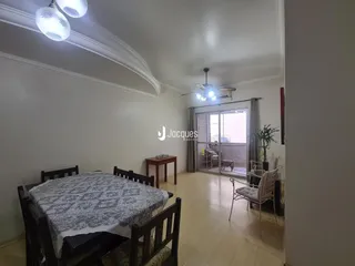 Foto de um ambiente interno com mesa de jantar e paredes brancas.
