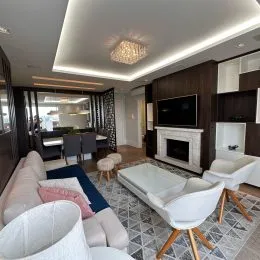 Sala de estar com sofá e lareira em um apartamento.