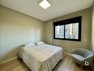 Quarto com cama e janela de grande porte em um imóvel.