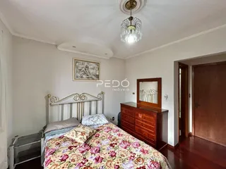 Quarto com cama e armário de madeira em um imóvel no Brasil.