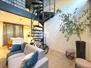 Sala de estar moderna com escadaria e plantas em um apartamento em Lajeado.