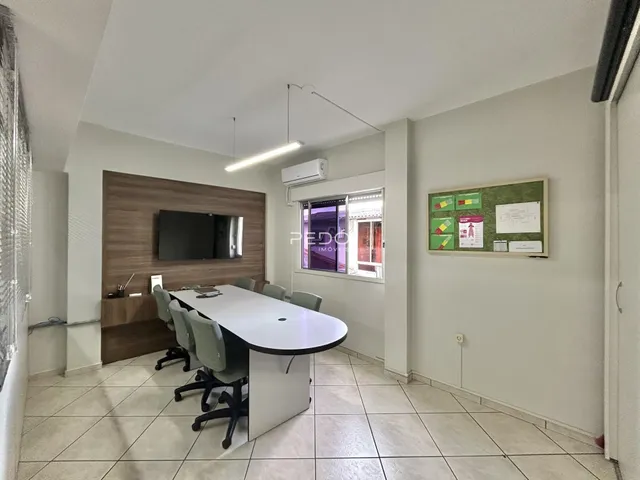 Sala de jantar com mesa longa e parede de madeira em um apartamento.