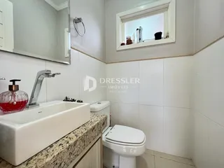 A foto mostra um banheiro interno com pia e vaso sanitário.