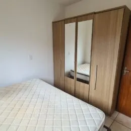 Foto de um quarto com cama e armário de madeira.