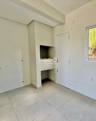 Interior de uma sala com paredes brancas e piso de cerâmica.