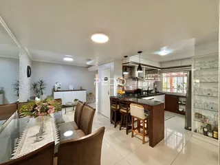 Sala de estar com cozinha e área de jantar em um ambiente aberto.