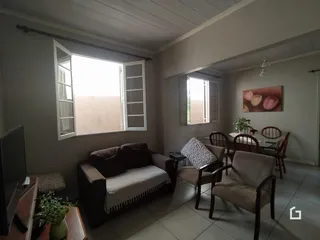 Sala de estar com sofá e mesa de jantar em um imóvel no Brasil.