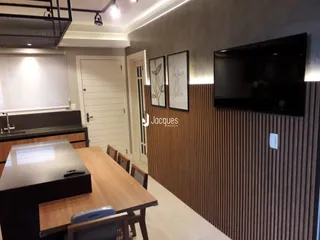 Imagem de uma sala com mesa de madeira e painel de madeira na decoração.