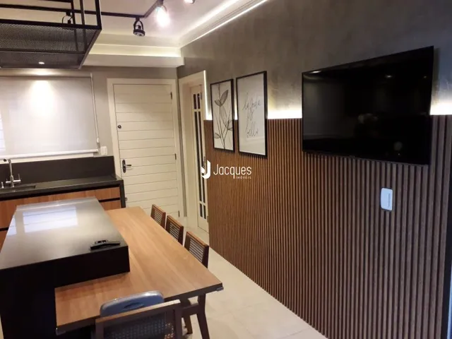 Imagem de uma sala com mesa de madeira e painel de madeira na decoração.