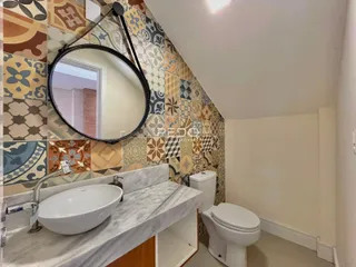 Foto de um banheiro com bancada de mármore e revestimento de azulejos.
