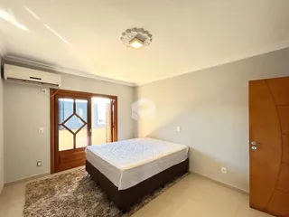 Quarto com cama e porta de madeira no interior da residência.