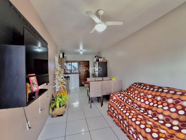 Sala de estar com piso de cerâmica branca e móveis de sala.