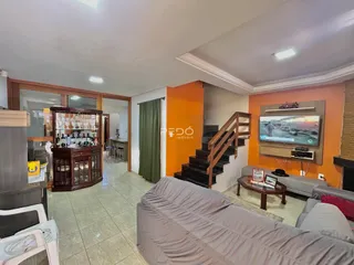 Sala de estar com decoração moderna e acesso a uma área de jantar e cozinha.