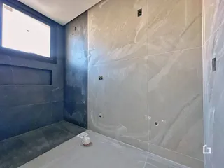 Parede interna com acabamento em tons de cinza e piso claro.
