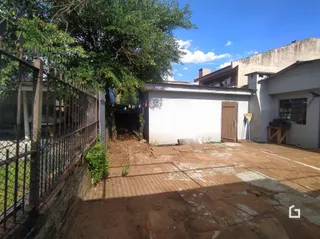 Vista externa de um terreno com cerca e vegetação.