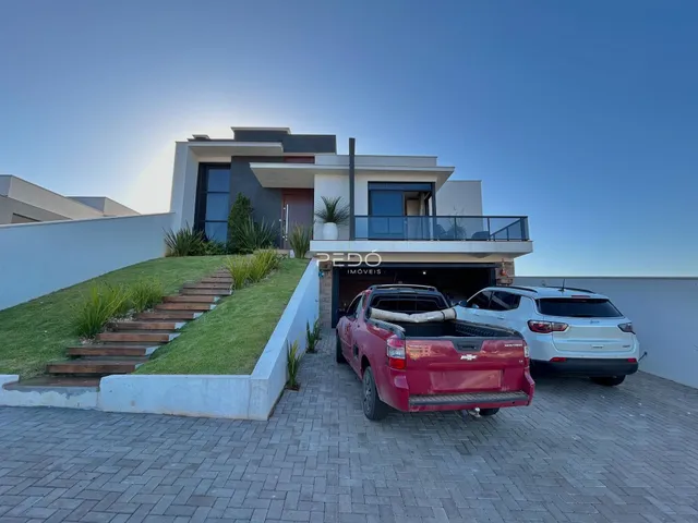 Fachada de uma casa moderna em Lajeado, Brasil, com jardim e garagem.