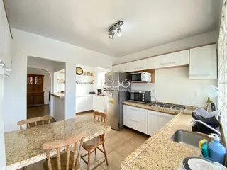 Foto de uma cozinha com bancadas de granito e armários brancos.