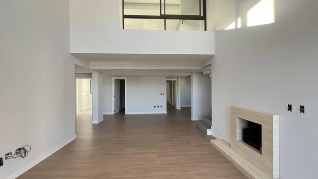 Hall de entrada com piso de madeira clara e parede de lareira moderna.