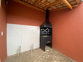 Parede com armários brancos e uma lareira escura em um ambiente interno.