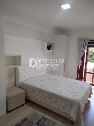 Quarto com cama de casal e paredes brancas