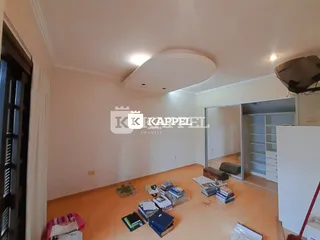 Foto de um ambiente interno com piso de cor terracota e teto branco.