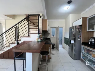 Imagem de uma área comum de uma residência em Lajeado, Brasil, mostrando uma cozinha e escadaria.