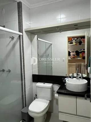 Foto de um banheiro interno com azulejos brancos e louças sanitárias.