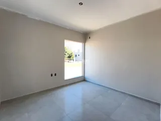 Interior de um ambiente com paredes brancas e piso de cerâmica.