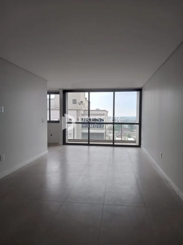 Esta é uma foto de um ambiente interno com piso claro e grandes janelas.