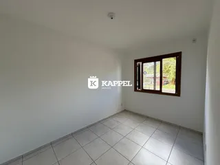 Vista interna de um cômodo com piso de cerâmica e janela.