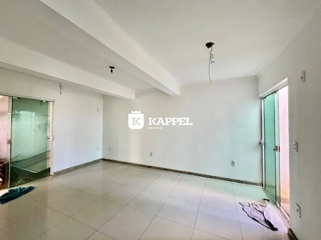 Sala ampla com piso de cerâmica e portas de vidro.