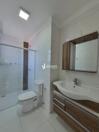 Foto de um banheiro moderno com revestimento branco e louças sanitárias brancas.