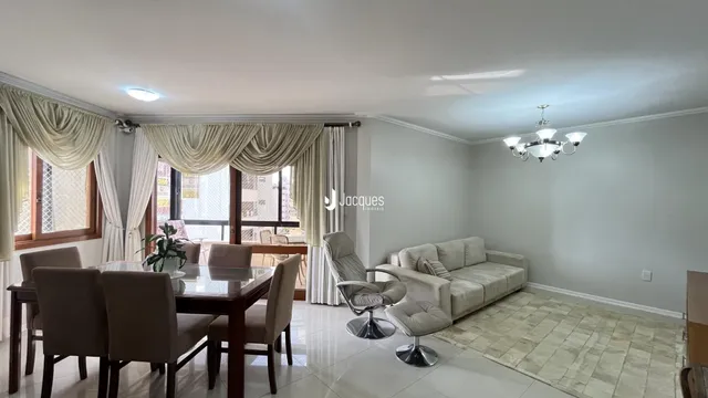 Sala de estar com sofá e mesa de jantar em um apartamento.