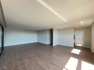 Ambiente interno amplo com piso de madeira clara.