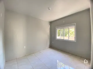Uma sala clara com piso de cerâmica e janela.