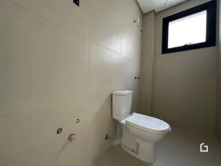 Foto de um banheiro interno com paredes brancas e piso claro.