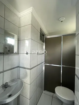 Foto de um banheiro com revestimento de azulejos brancos.