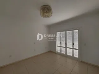 Sala de estar com piso de cerâmica e porta de vidro