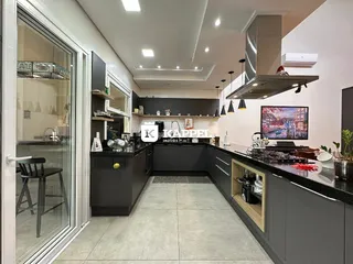 Vista interna de uma cozinha moderna com armários escuros e ilha.