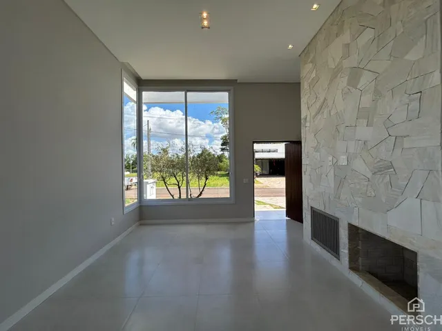 Sala ampla com grande janela voltada para a paisagem externa.