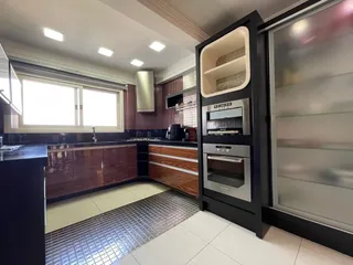 Foto de uma cozinha com armários de madeira e bancadas escuras.