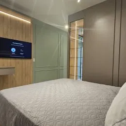 Foto de um quarto com cama de casal coberta com lençóis brancos.