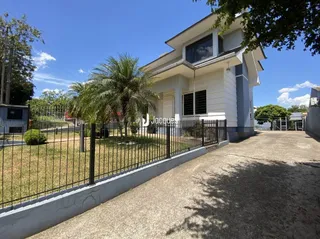 Vista da fachada de uma residência com cerca e jardim em Lajeado.
