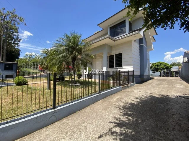 Vista da fachada de uma residência com cerca e jardim em Lajeado.
