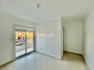 Interior de uma sala com porta de vidro abrindo para o exterior.
