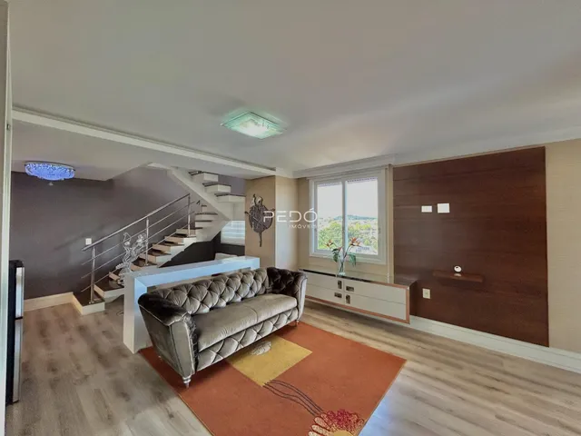 Sala de estar com sofá e escadaria em um apartamento.