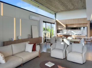 Sala de estar moderna com grandes portas de vidro e vista para o exterior.